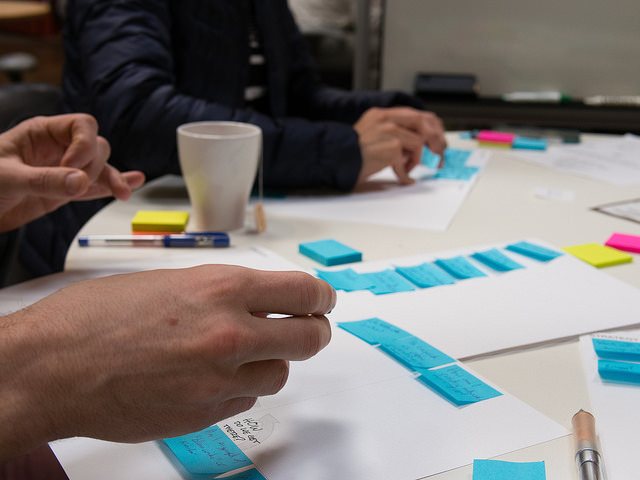People in a group creating an MVP prototype with post-it notes